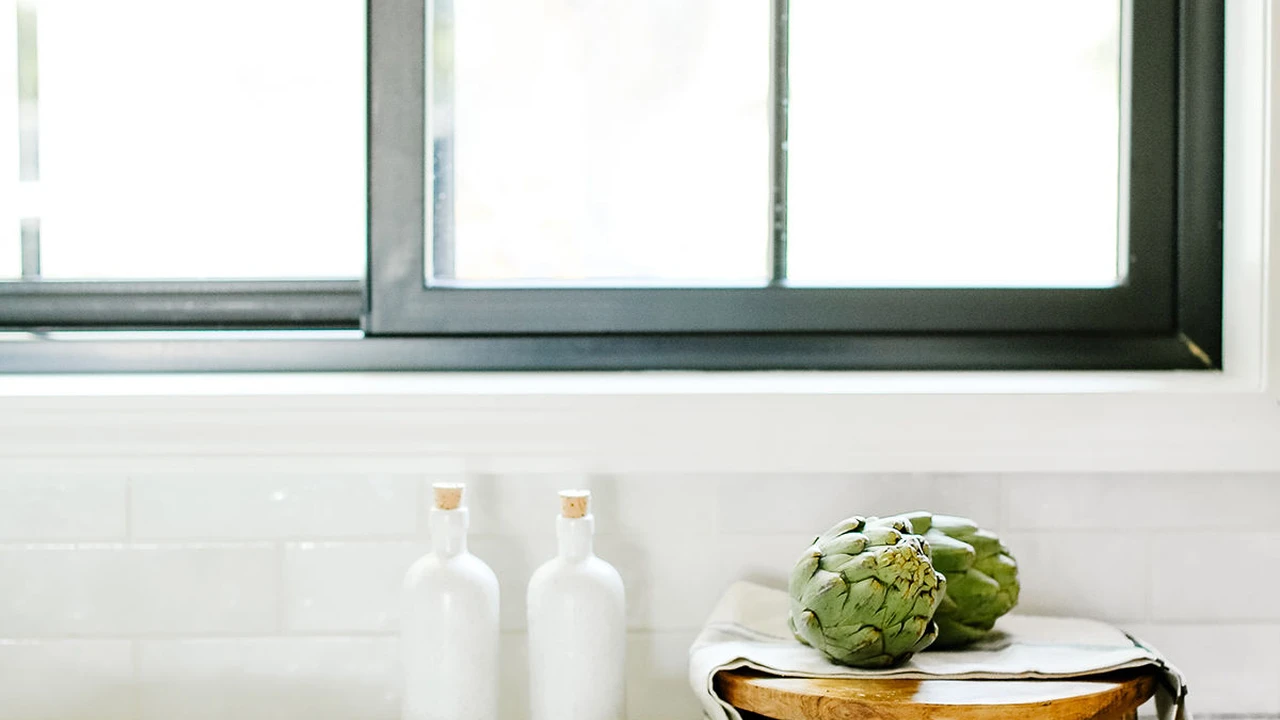 Close up on a plate of mashed potatoes, topped with baked pork chops with cream of mushroom soup, and a side of green beans.