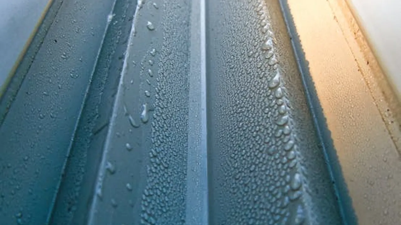 Close up on a plate of mashed potatoes, topped with baked pork chops with cream of mushroom soup, and a side of green beans.